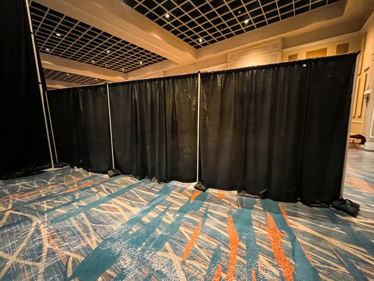 white pipe and drape backdrop behind a wedding stage setup with twinkle drape overlay, soft lighting