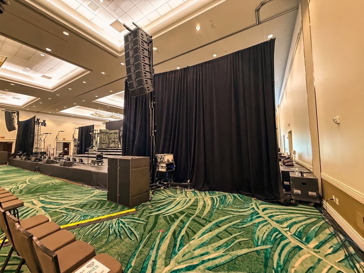 stage setup with pipe and drape backdrop at a corporate holiday gala inside a Florida hotel ballroom