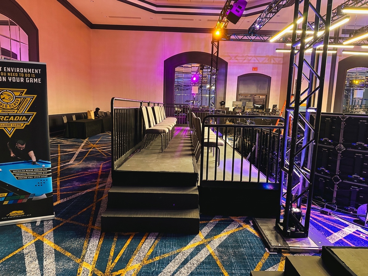 professional stage installation in progress at an indoor-outdoor venue in Winter Park, showing crew positioning stage decks under event lighting