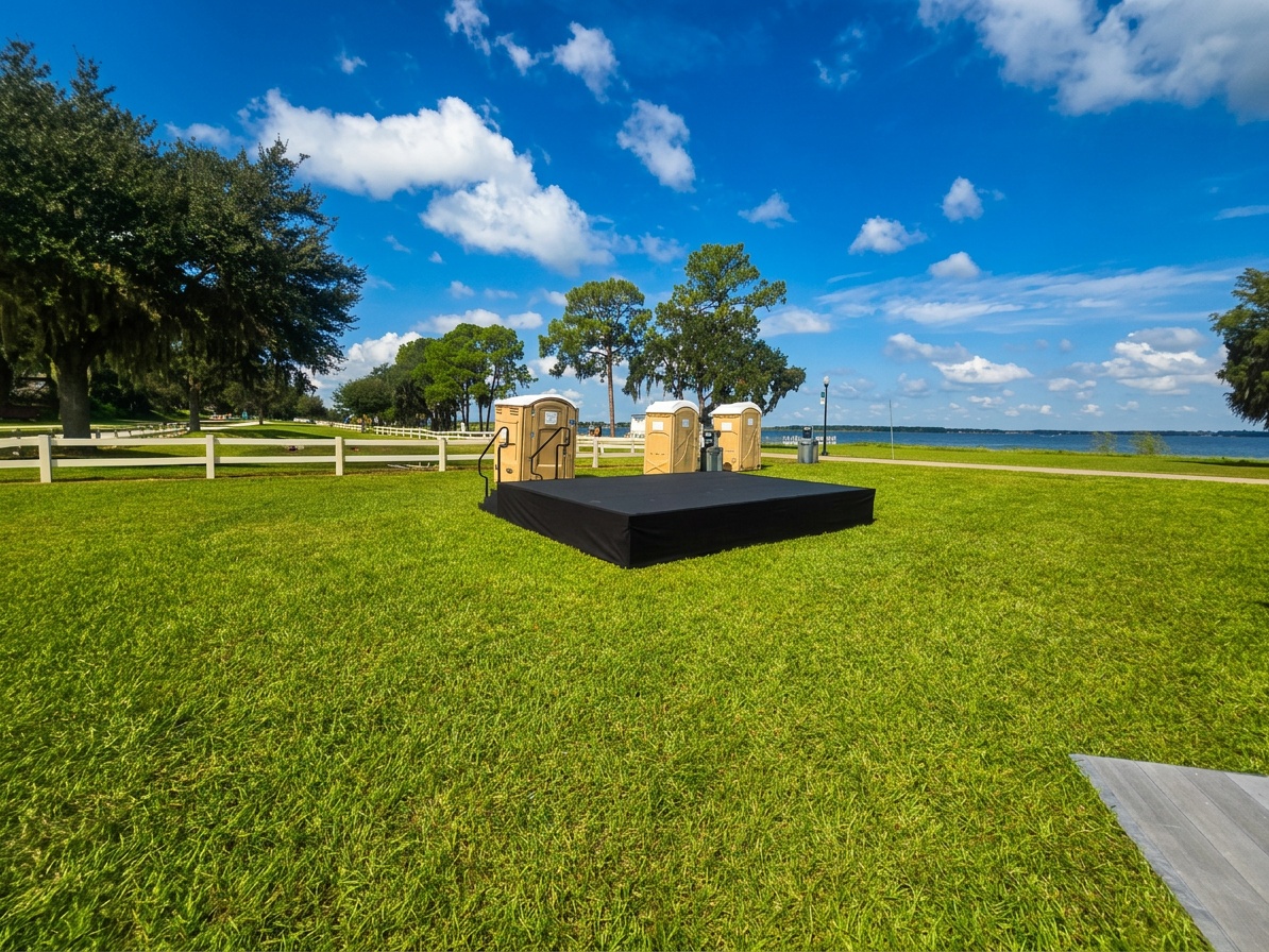 aerial view of an outdoor festival setup in a Central Florida park with a covered concert stage and crowd