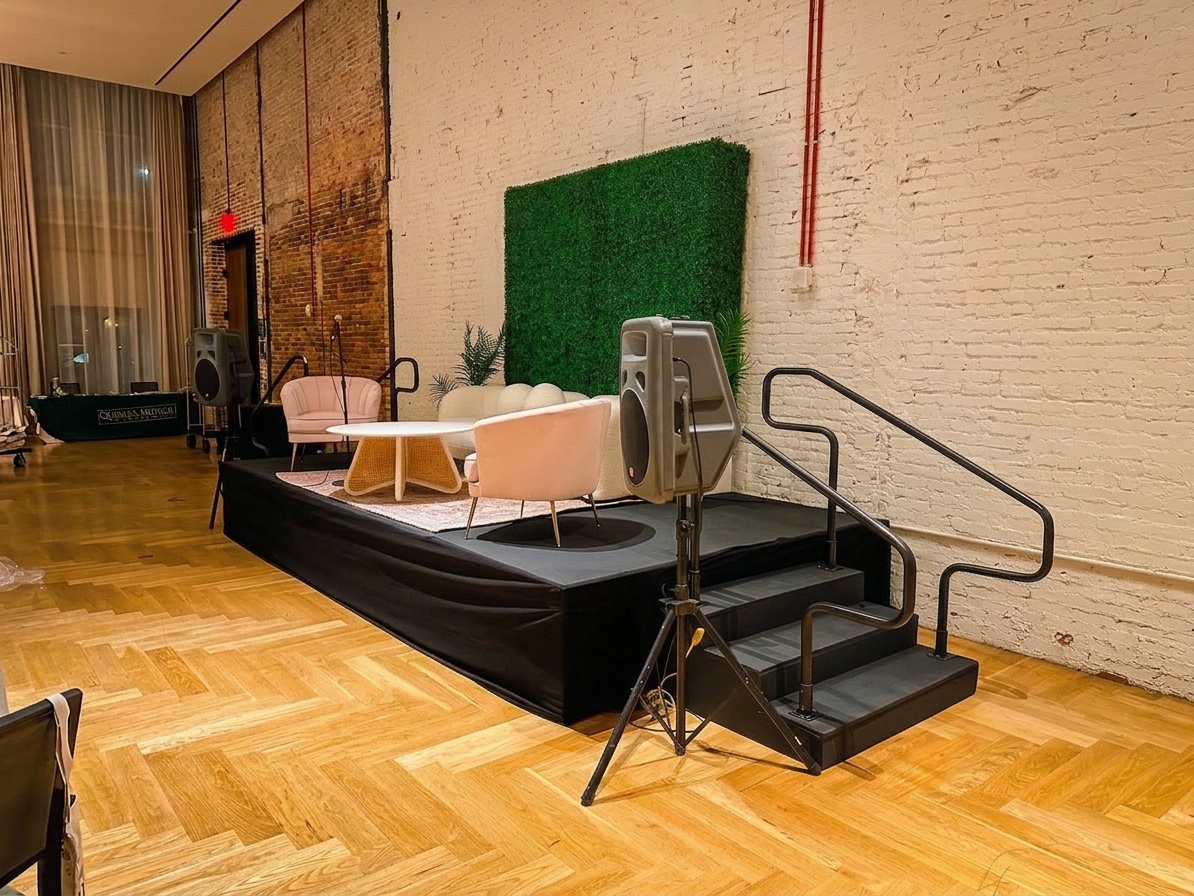 compact stage setup in an intimate hotel ballroom with visible front clearance between the stage edge and the first row of chairs